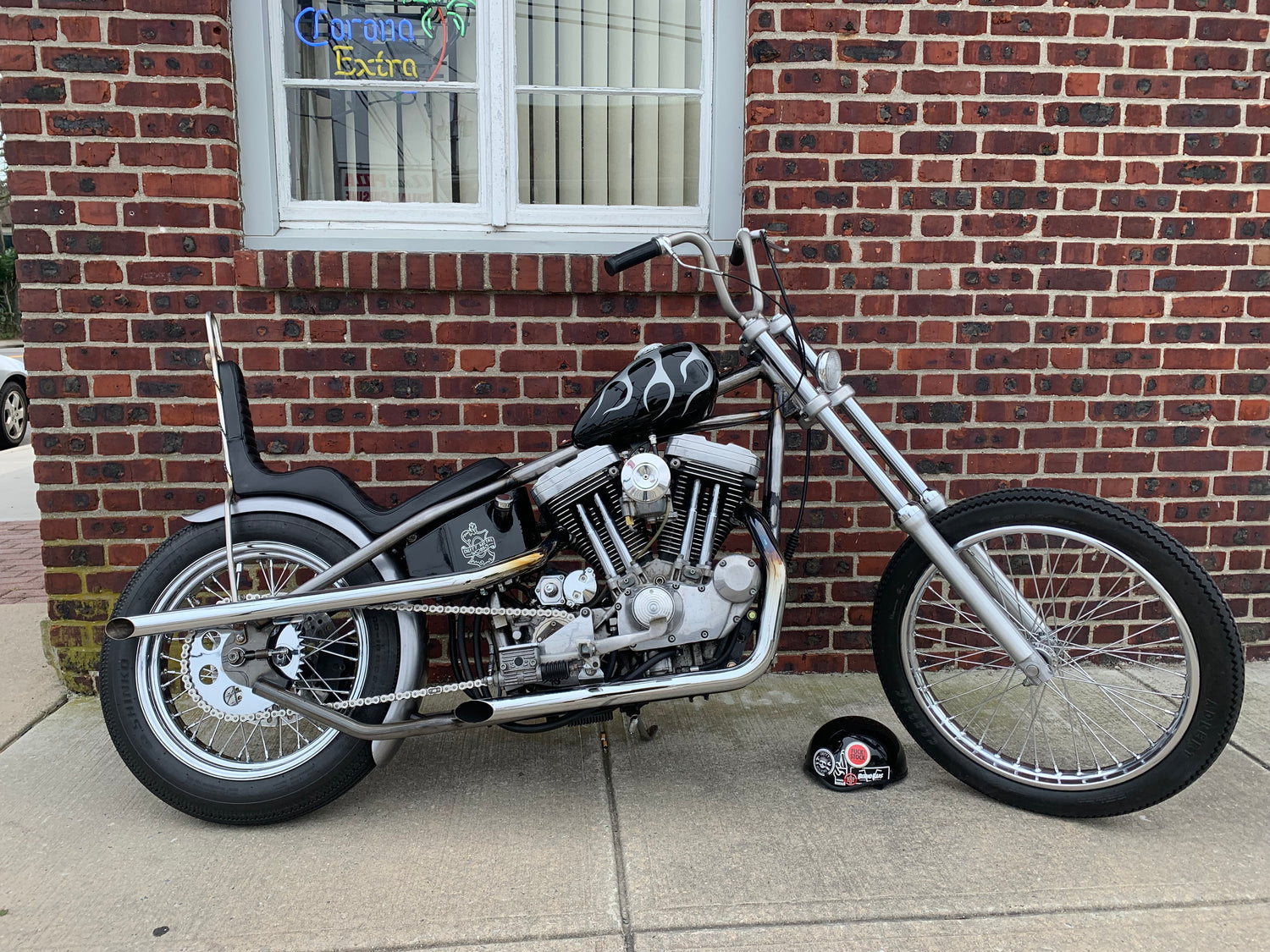 sportster chopper black with grey flames in front of brick walls