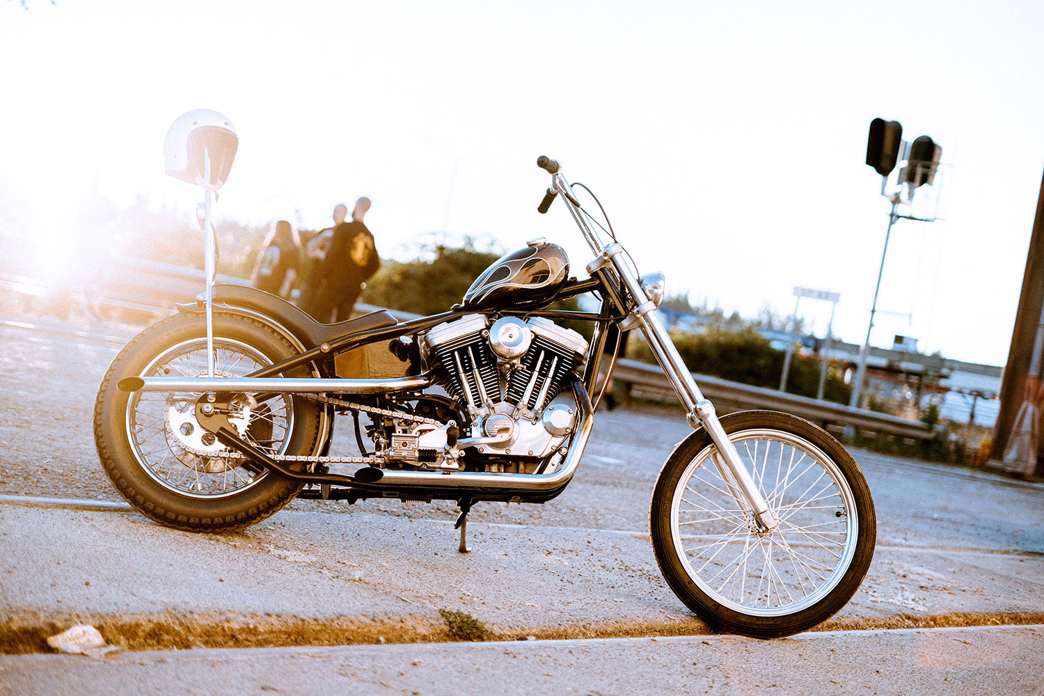 black sportster chopper with grey flames in front of sunset